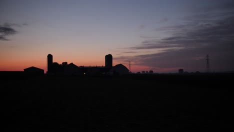 Ein-Roter-Sonnenaufgang-über-Einer-Farm-An-Einem-Sommermorgen