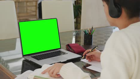 Asian-teenage-boy-using-laptop-for-video-call,-with-copy-space-on-screen