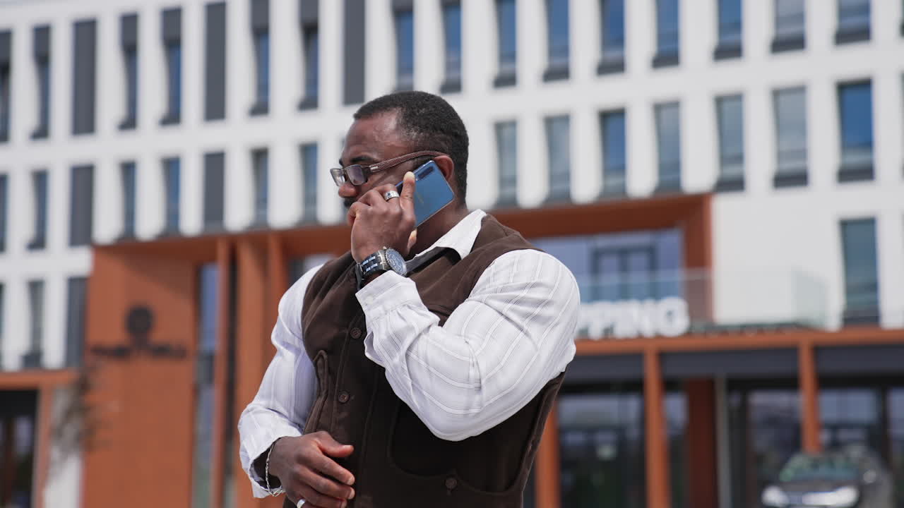 African american man having a phone conversation. Cheerful black man with muscular body talking the phone on urban background.