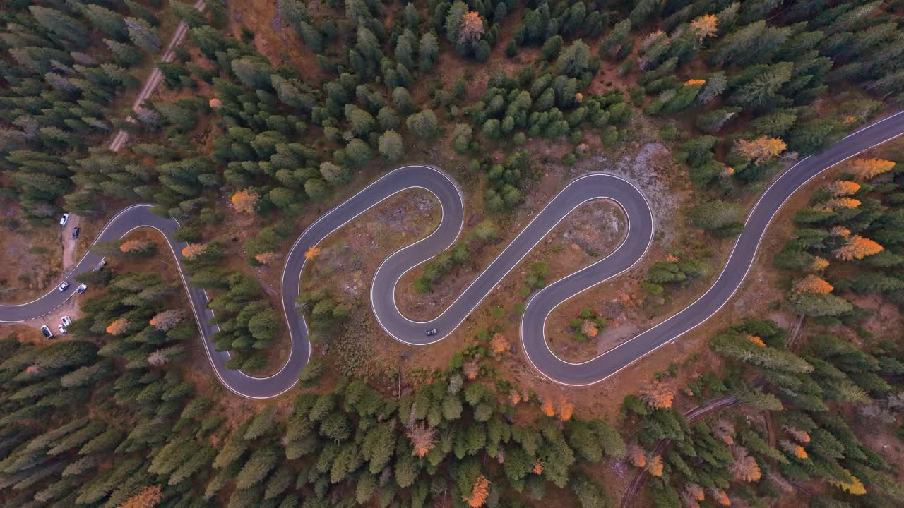 Snake Road curves through fall colors in Dolomites, seen from above