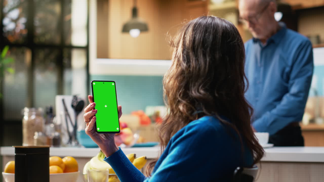 Mockup display on phone at kitchen table with elderly woman smiling