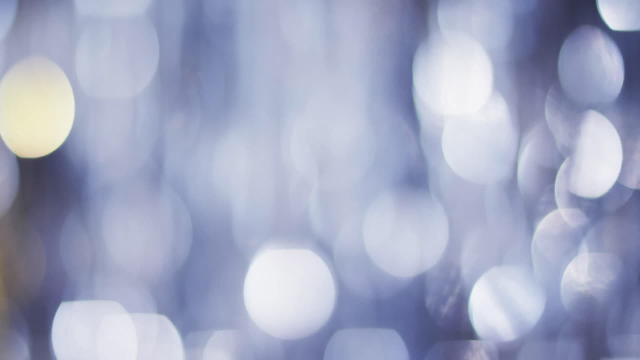 Video of flickering white and blue bokeh spots of light with copy space