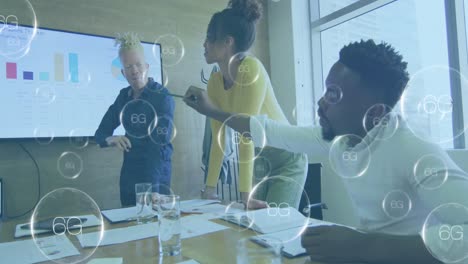 animation of multiple 6g round text banners over diverse colleagues discussing together at office