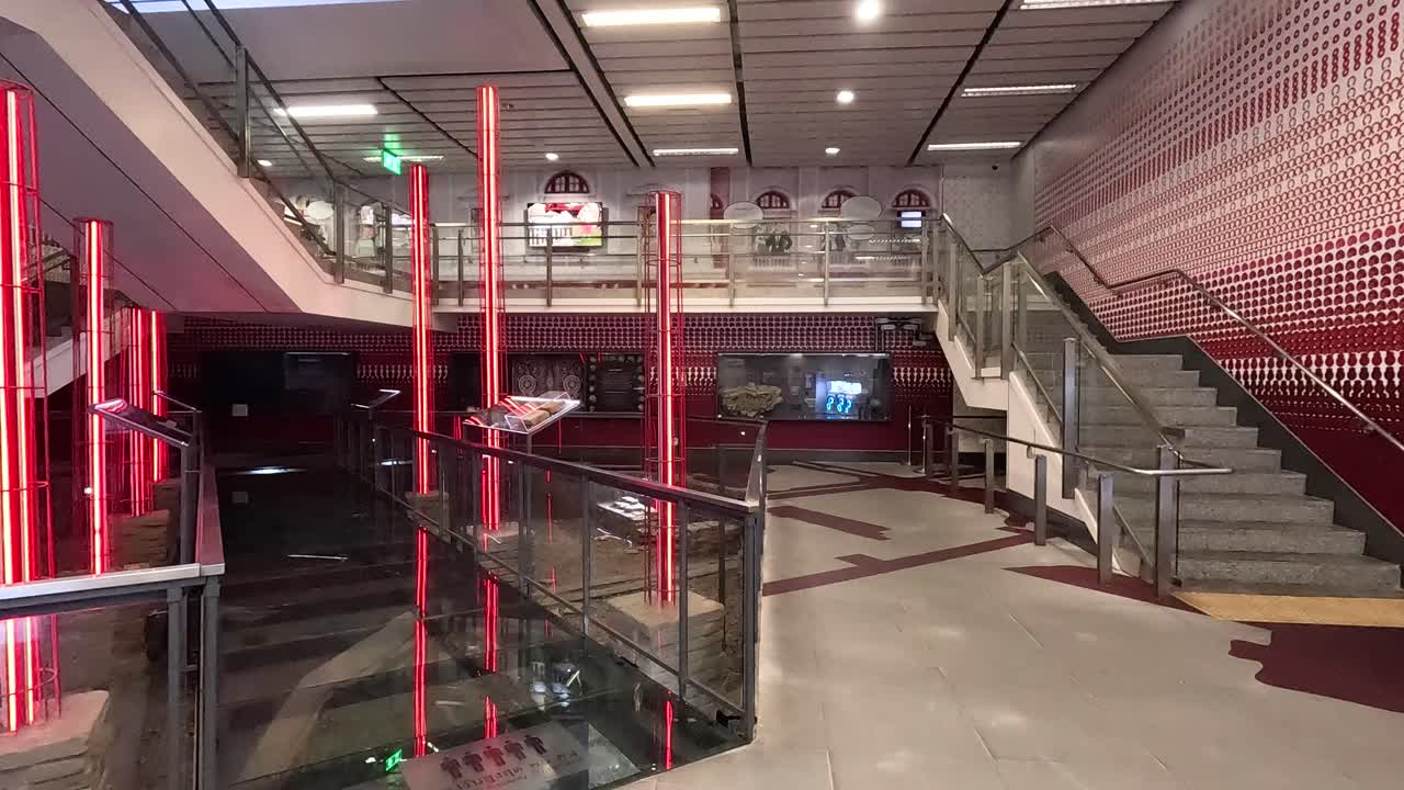 현대적인 실내 환경에서 빨간 네온 불빛으로 활기찬 계단, 건축 디자인과 역동적인 조명을 보여줍니다.