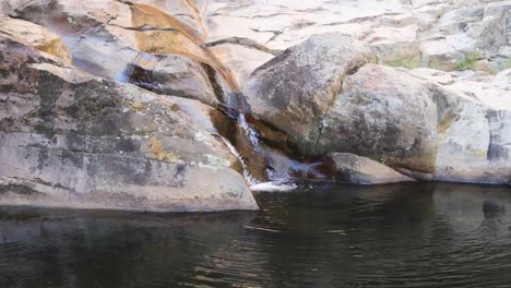 Kleiner-Wasserfall,-Der-über-Felsen-In-Ein-Dunkles-Becken-Fließt