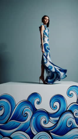 fashion model showcasing flowing blue and white wave pattern dress