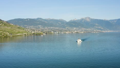 flying in reverse over lake léman with belle-epoque steam boat, vevey, montreux and the alps in the background - switzerland