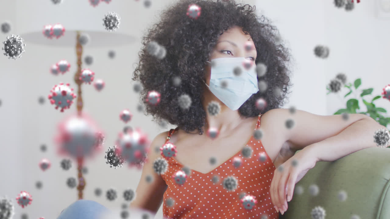 Animación de células virales sobre mujer afroamericana con mascarilla facial