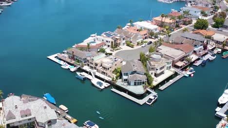 Drehende-Luftaufnahme-Von-Wunderschönen-Multimillionen-Dollar-Luxushäusern-An-Der-Bucht-Entlang-Eines-Kanals-Am-Meer