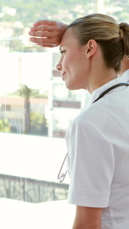 thoughtful doctor looking through windows