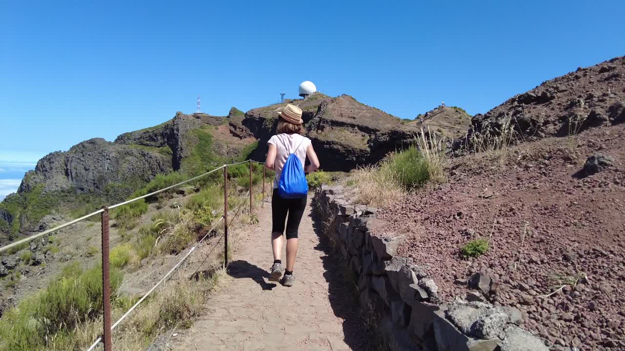 Mujer caminando por un sendero de montaña
