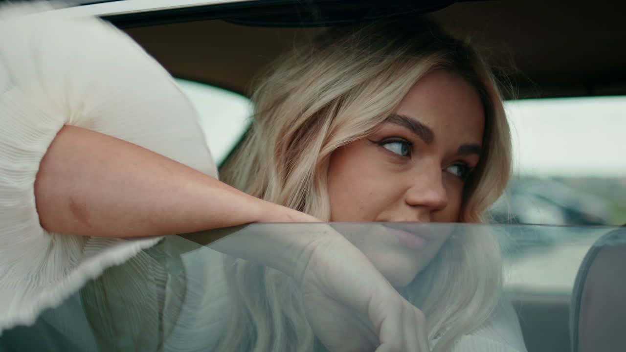 una chica mirando por la ventana del coche. una chica sentada en el asiento trasero de un automóvil retro.