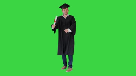 male student in graduation robe posing with his diploma making funny faces on a green screen, chroma key