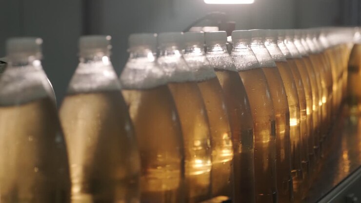Conveyor belt with bottles for juice or water at a modern beverage plant. Modern production of sweet soda water