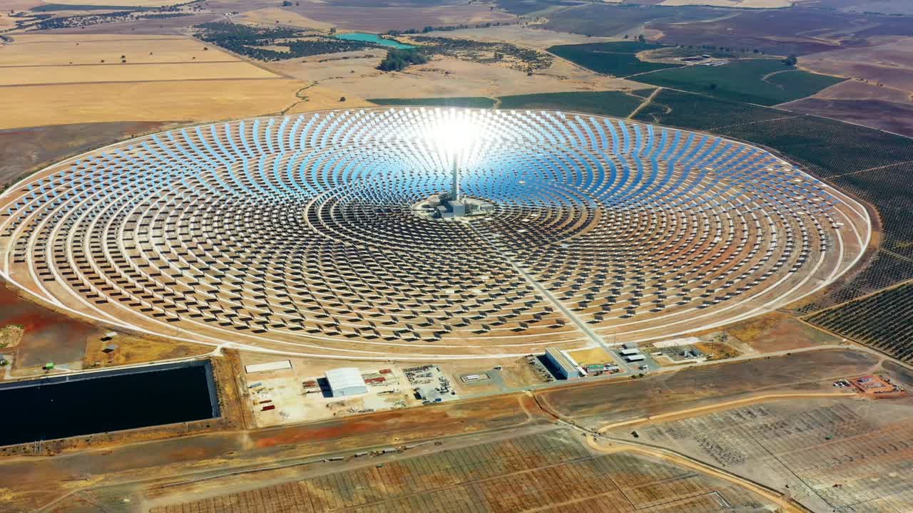 planta de energía de paneles solares fotovoltaicos. planta de energía termosolar, un centro de granja solar rodeada de campos - vista panorámica con un dron - concepto de medio ambiente