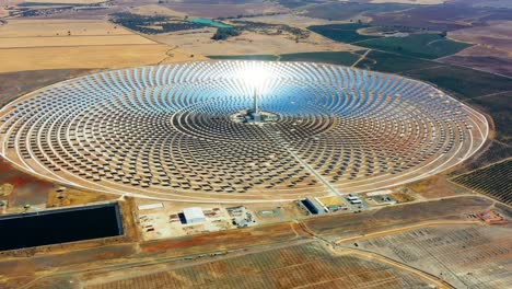 photovoltaic solar panels power plant. thermosolar power plant, a center of solar farm surrounded by fields - panorama view with a drone - environment concept