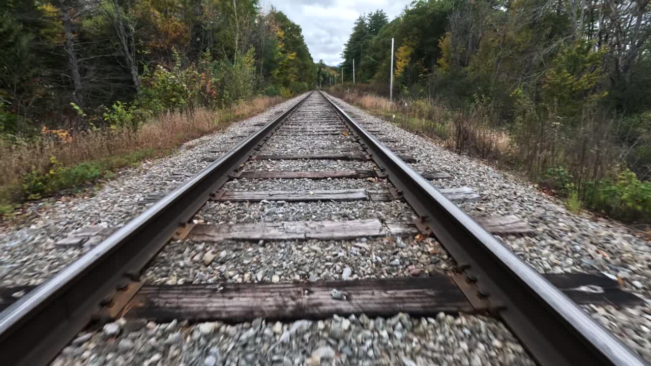 фпв-дрон, летящий над железной дорогой в осеннем пейзаже, пиковые цвета