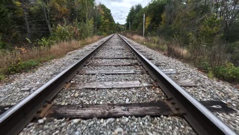 FPV-Drone-Flying-Over-Railway-In-Fall-Landscape,-Peak-Colors