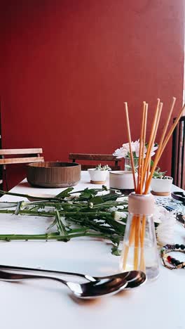 floral arrangement on a white table with a red wall