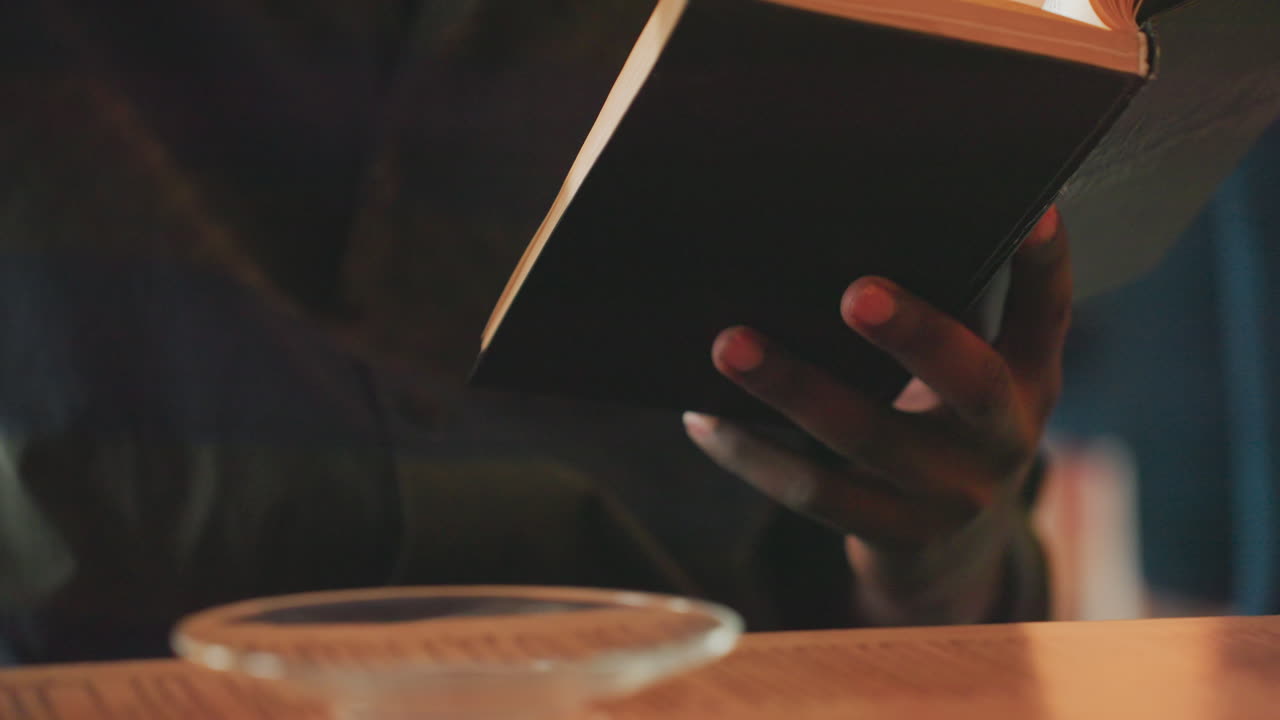 student studies tea, evening reading session with hot beverage, focus on studying with warm cup on wooden table, student engaging in evening reading alongside cup of tea on aged wood