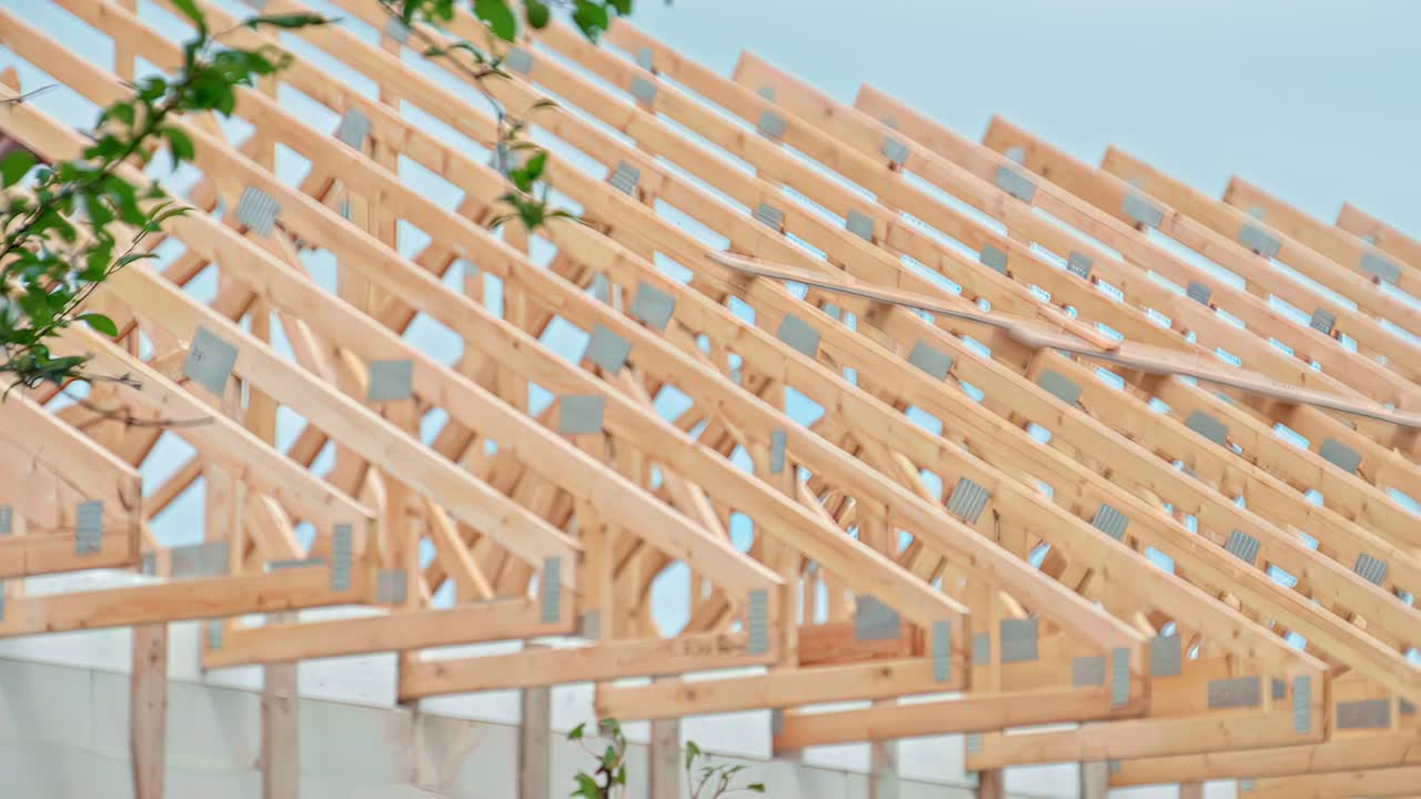 Nouvelle charpente de toit en bois avec des poutres en bois fraîchement installées sur un projet de construction en cours