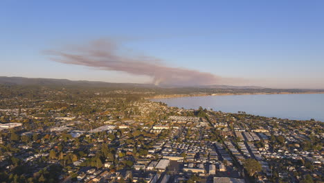 Volando-Sobre-La-Ciudad-De-Watsonville-Con-El-Humo-De-Un-Incendio-Forestal-En-El-Fondo