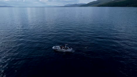 drone pull back from speedboat to reveal montana lake and mountains