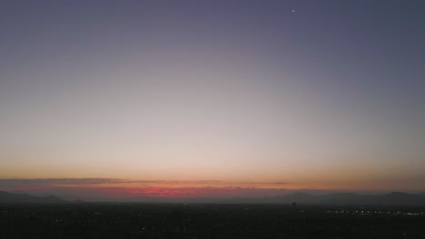 aerial view at santiago de chile with the mountains and the moon in the background in the middle of the sunset