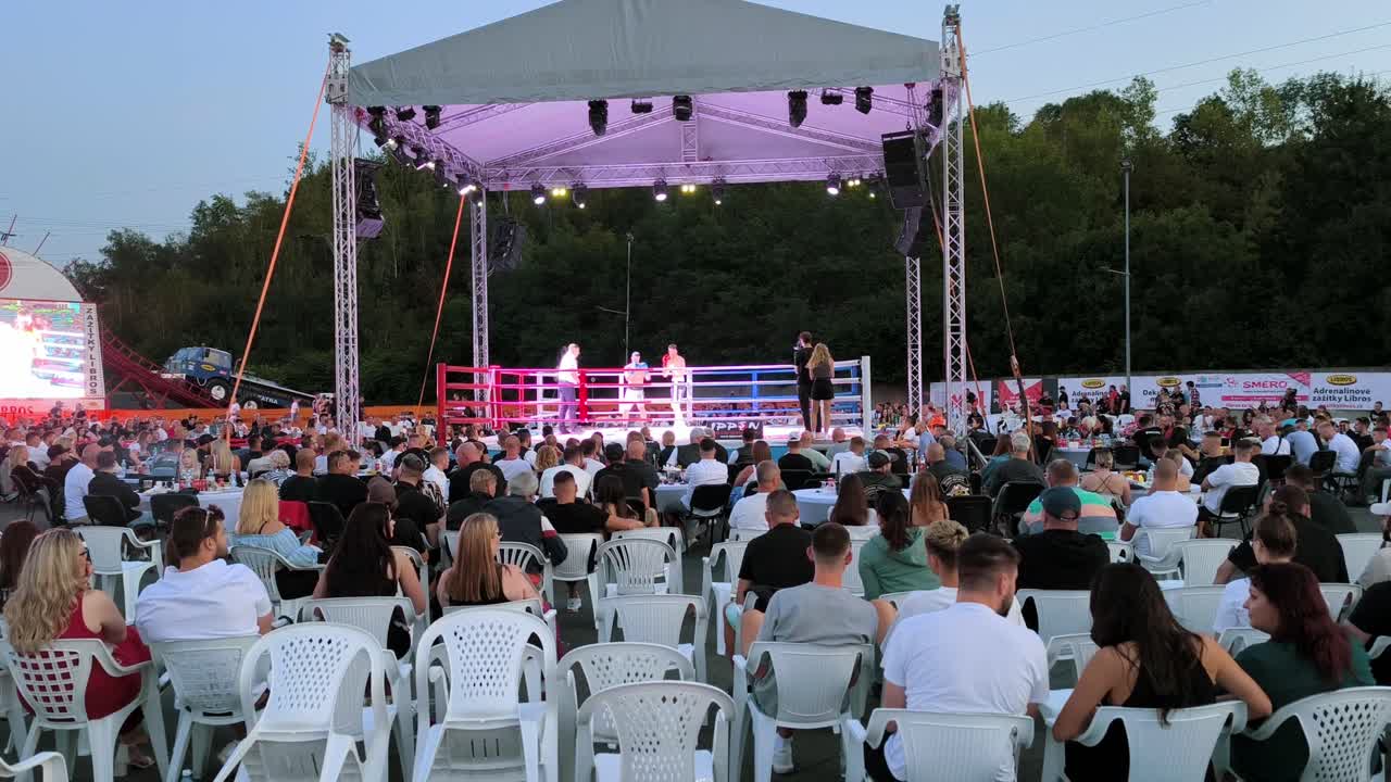 Slow-motion clip of a boxing match, with intense punches and movements in a boxing ring as people watch
