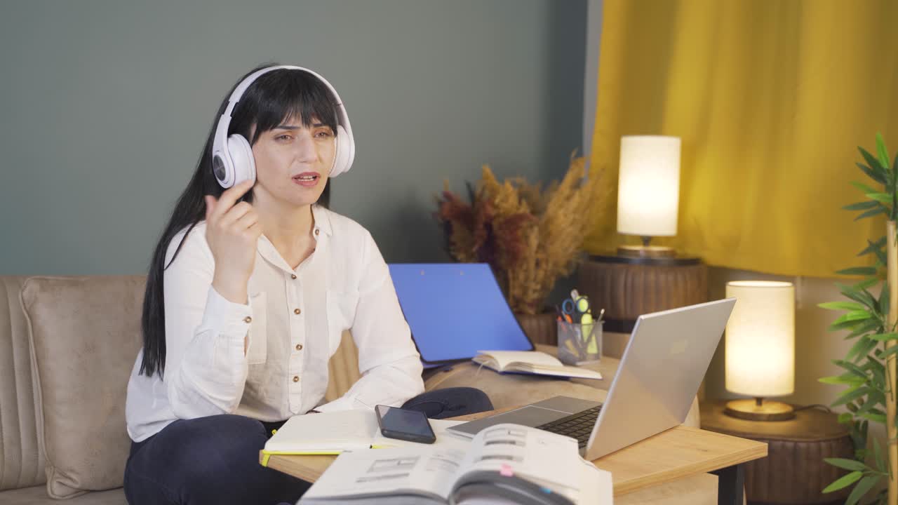 우울한 여성이 밤에 집에서 음악을 듣고 있습니다.