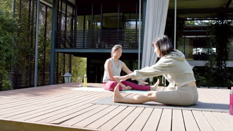 Glückliche-Asiatische-Freundinnen-Strecken-Und-Lächeln-Auf-Der-Sonnigen-Terrasse,-Zeitlupe