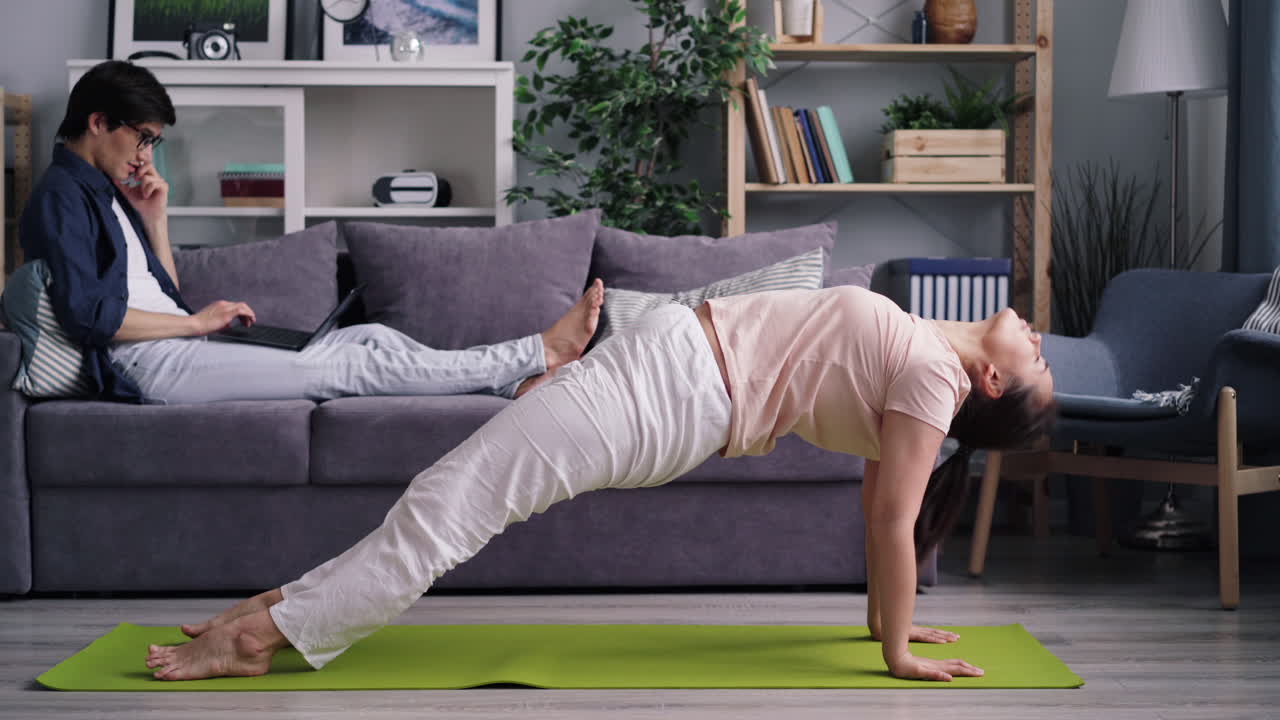 pareja practicando yoga en casa