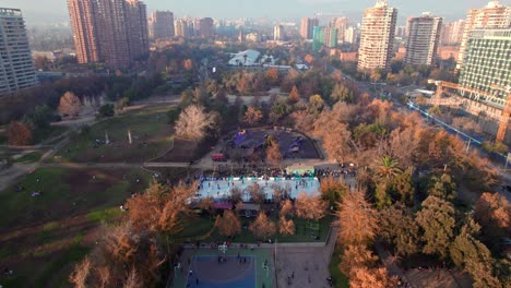 Dolly-En-Tilt-Up-Vista-Aérea-Del-Parque-Araucano-Con-El-Cerro-El-Plomo-Al-Fondo,-Santiago,-Chile