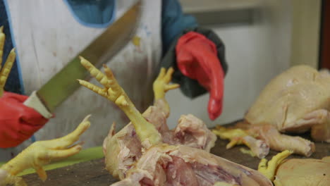 a market vendor cutting up raw chicken with a large knife in ollantaytambo, peru