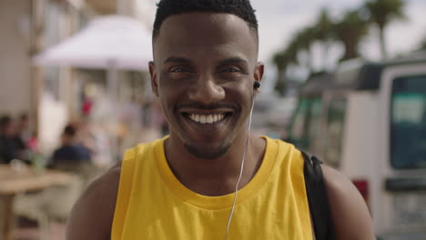 retrato sonriente de un atractivo hombre afroamericano con auriculares escuchando música