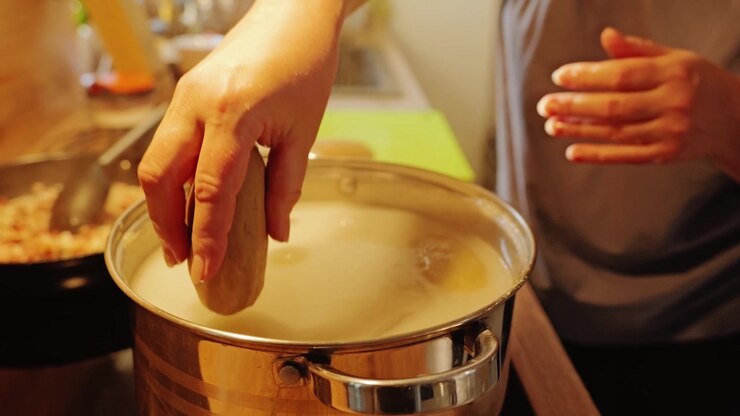 Il rallentatore riprende cepelinai fatti a mano delicatamente calati in acqua per la cottura.