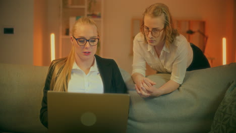 dos mujeres discuten el proyecto en la computadora portátil durante una reunión en casa