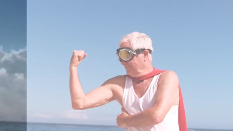 Animation-of-clouds-over-happy-senior-caucasian-man-wearing-superhero-costume-on-beach