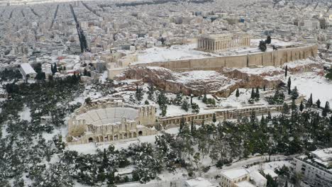 aerial view away from the snow covered acropolis hill, rare snowy day in athens, greece - pull back, drone shot