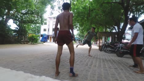men playing a traditional kicking game on a street