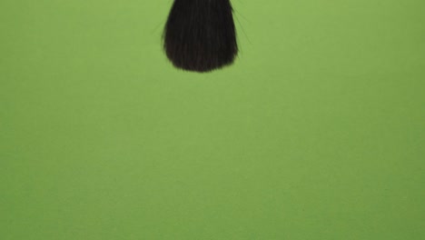 movement of the makeup brush to the top on a green background