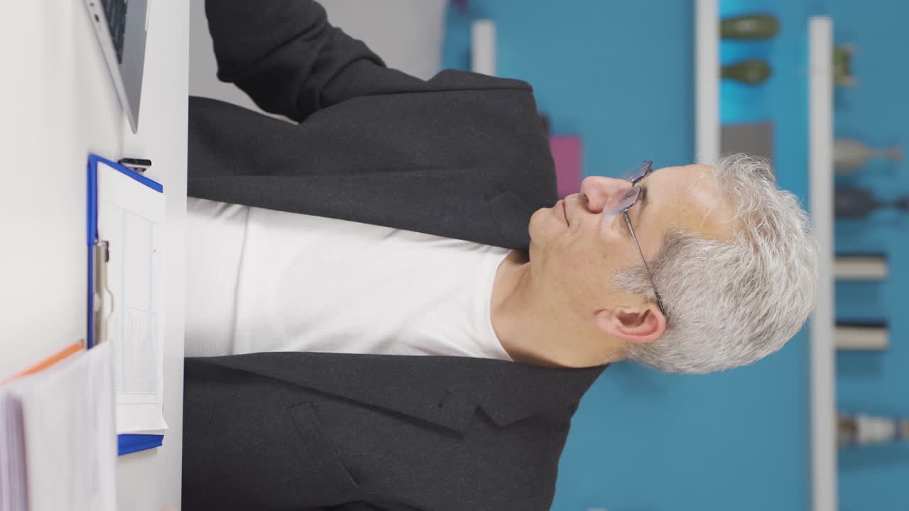 vídeo vertical de un trabajador de oficina en casa trabajando con concentración.