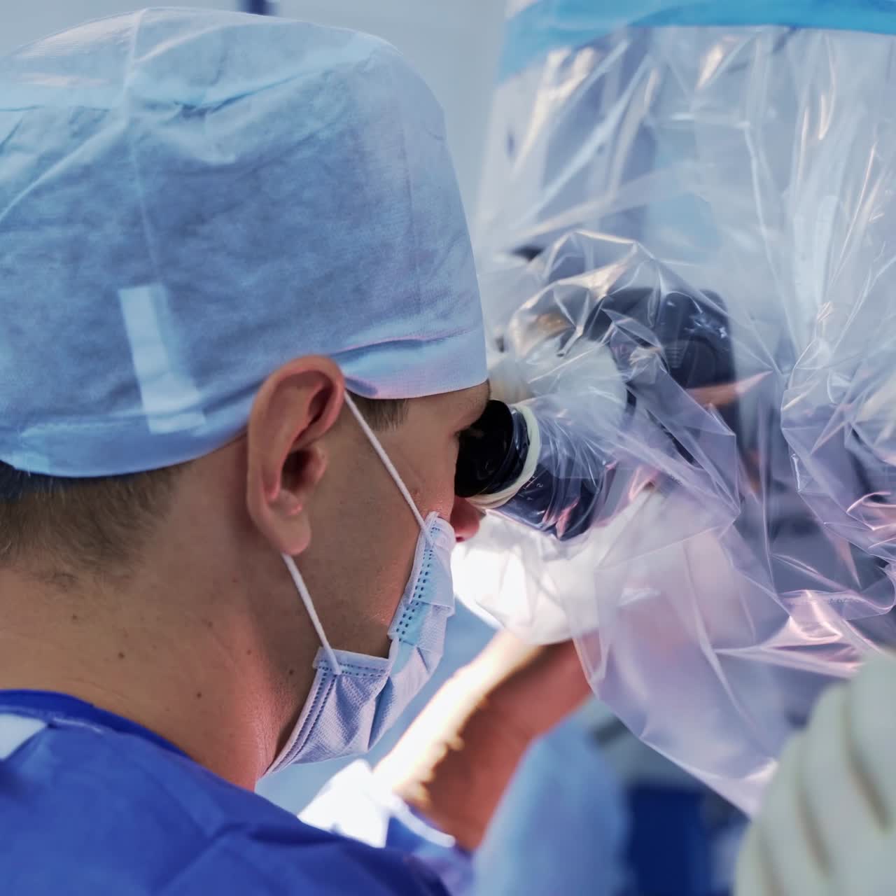 Doctor in mask near the microscope. Group of medical specialists operate the patient. Profile view of a surgeon. Close-up.