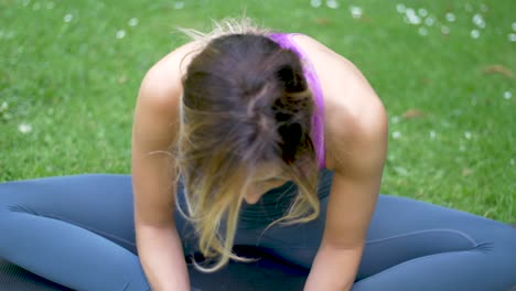 Close-up-view-of-woman-stretching-and-doing-yoga-on-a-mat-while-focused-on-her-breathing-and-exercise