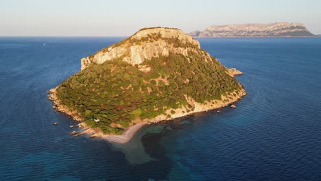 isla rocosa de figarolo durante la puesta de sol en golfo aranci, cerdeña, italia - antena 4k