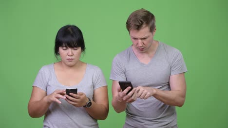 young multi-ethnic couple using phone and getting bad news together