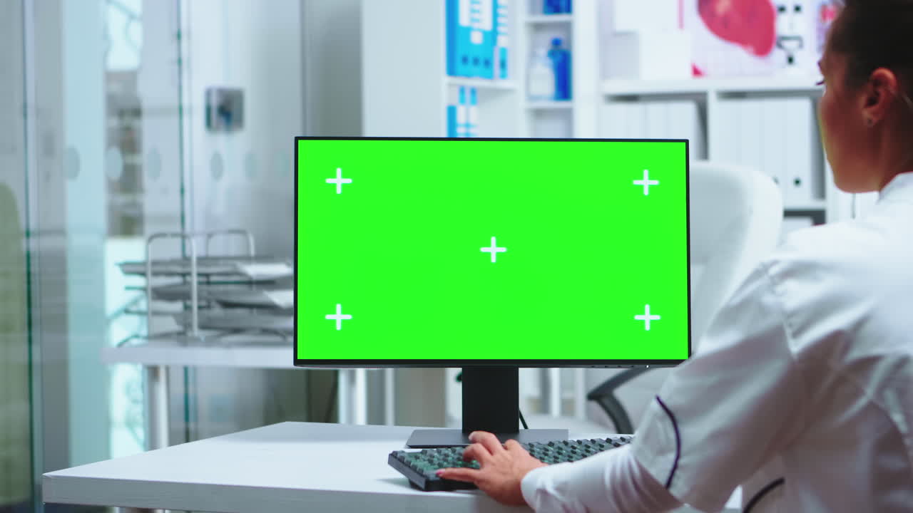 doctora trabajando en una computadora de pantalla verde.