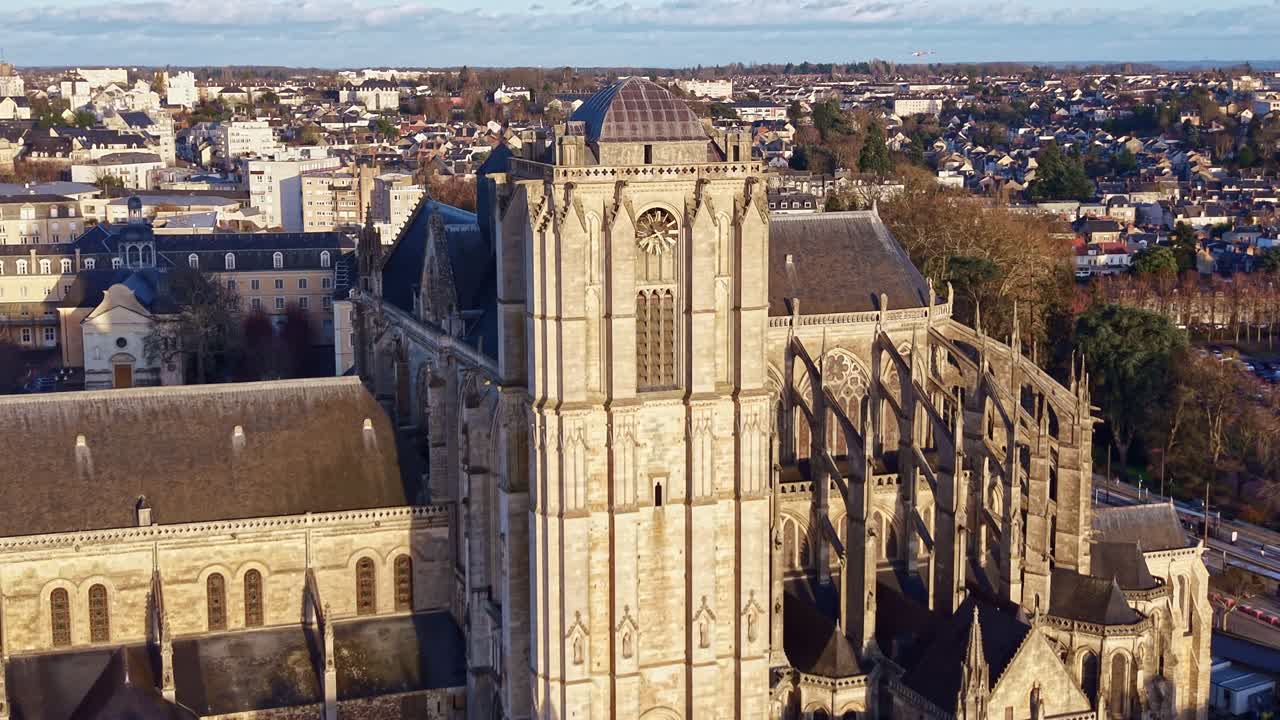 Drone Recuando e Subindo Acima da Torre da Catedral de Le Mans ao Pôr do Sol, Revelando a Paisagem Urbana Circundante Enquanto a Luz Dourada Ilumina a Fachada de Pedra Histórica. França