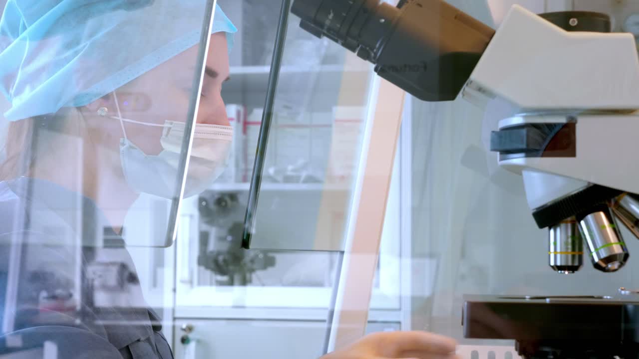 científico usando el microscopio en un laboratorio