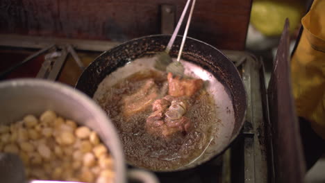 A-genuine-glimpse-into-a-local-kitchen-in-Cusco,-Peru,-where-they-prepare-the-traditional-"Chicharrón-de-Chancho"-served-with-Peruvian-corn-known-as-"choclo